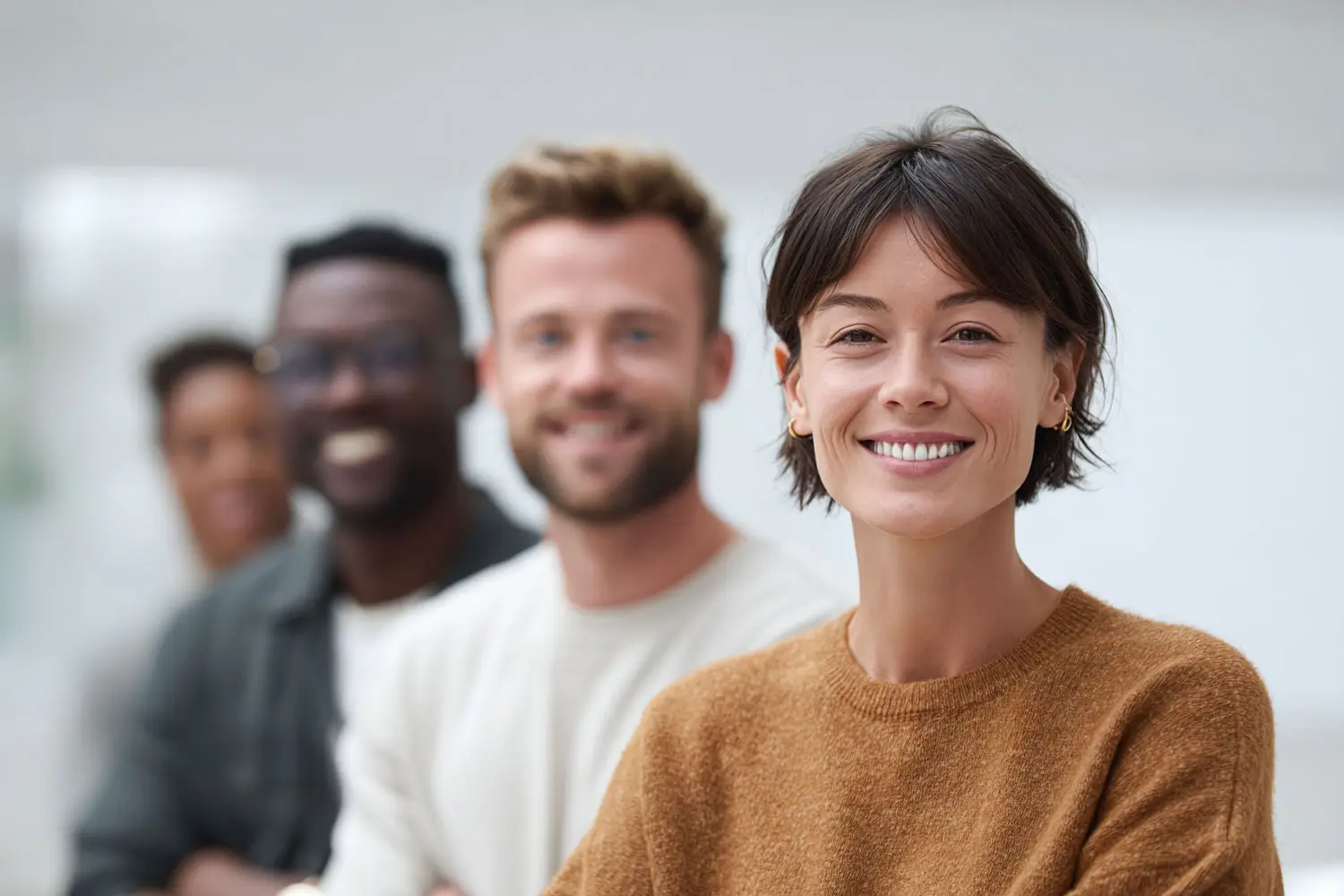 Un groupe de jeunes professionnels regardent l'objectif en souriant.